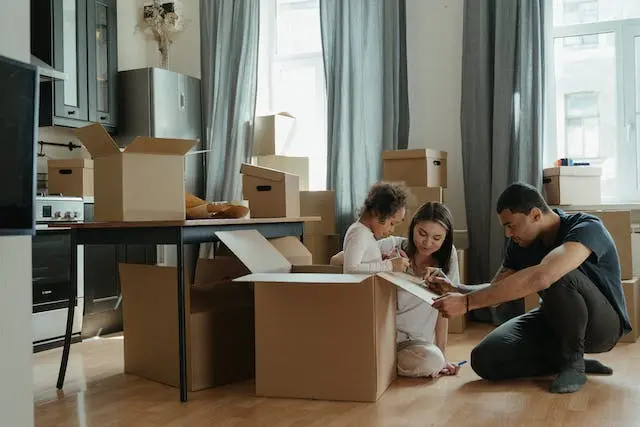 Família recien mudada montando muebles con cajas por el suelo